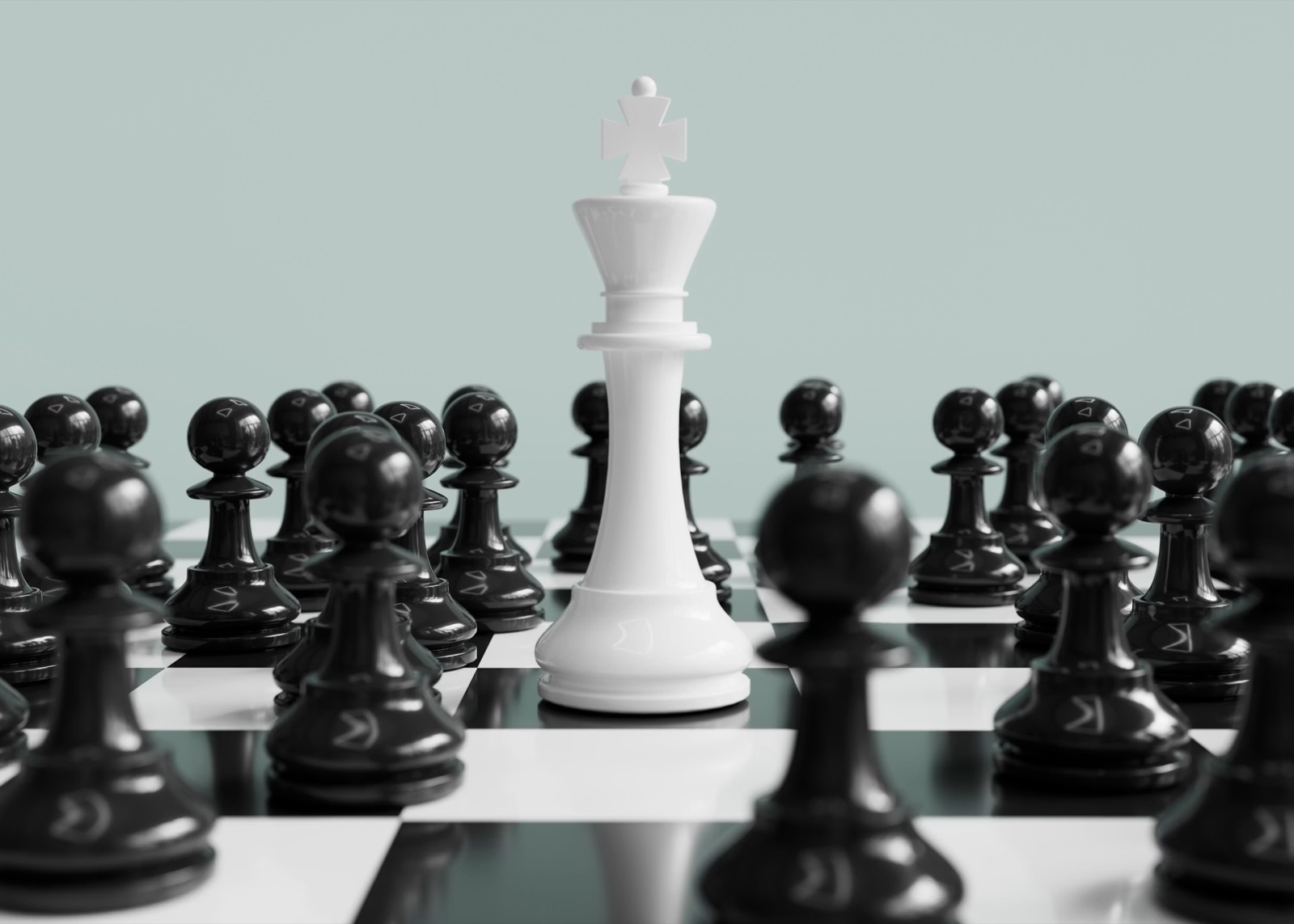 A white chess king standing in the middle of a field of black pawns