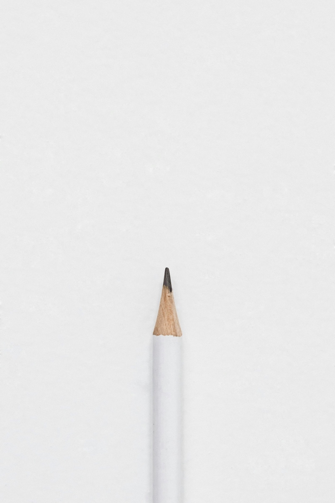 A single sharpened pencil tip on a plain gray background